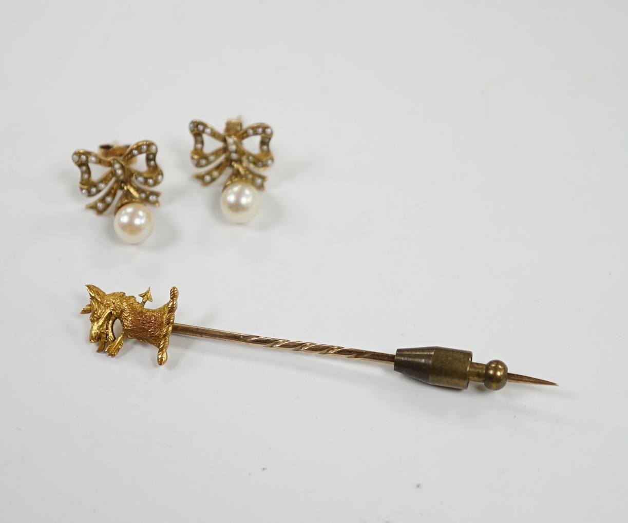 A pair of 9ct, single stone cultured pearl and seed pearl cluster set 'ribbon bow' drop ear studs, 17mm, together with a yellow metal 'armorial' stick pin. Condition - fair to good